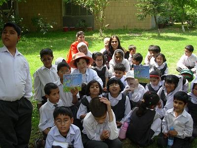 パキスタン・イスラマバードの特別支援学校（目の不自由な子ども対象）校庭にて。『Sadako`s Prayer』作者 ファウジア・ミナラさんと子どもたちと共にワークショップをしている渡部代表